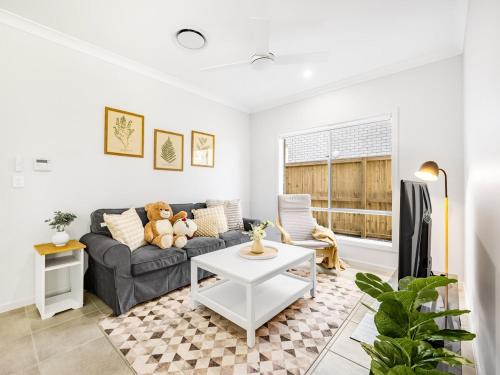 a living room with a couch and a table at Cozy Designer 4 Bedrooms Home Near Local Shops in Browns Plains