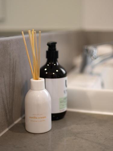 a bottle of soap sitting next to a bathroom sink at Cozy Designer 4 Bedrooms Home Near Local Shops in Browns Plains