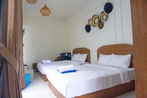 a bedroom with two beds with white sheets at M Bali 2 in Ngaglik