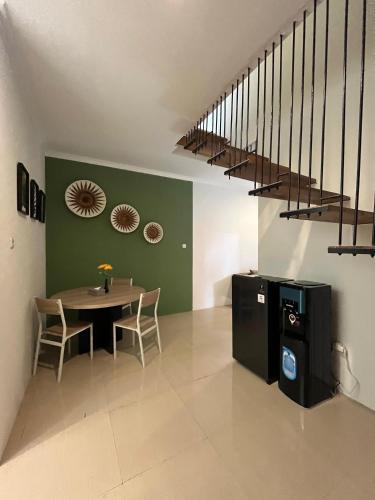 a dining room with a table and a staircase at Sampai Town Hotel in Adi Sutjipto