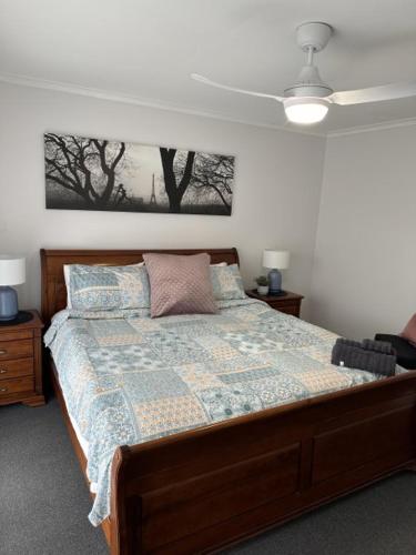 a bedroom with a bed and two tables and a ceiling at Lbarza Family Friendly 3BR with backyard & single garage near Hospitals & Sporting grounds in Shepparton