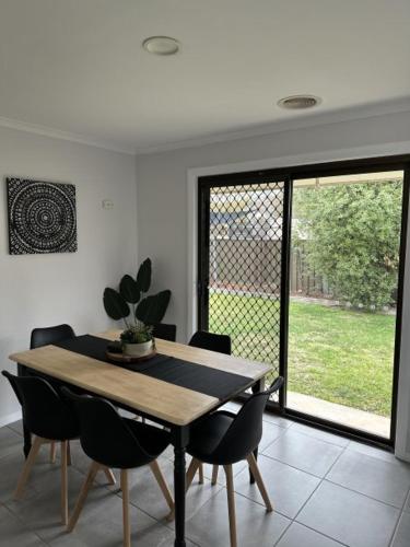 a dining room with a table and chairs and a window at Lbarza Family Friendly 3BR with backyard & single garage near Hospitals & Sporting grounds in Shepparton