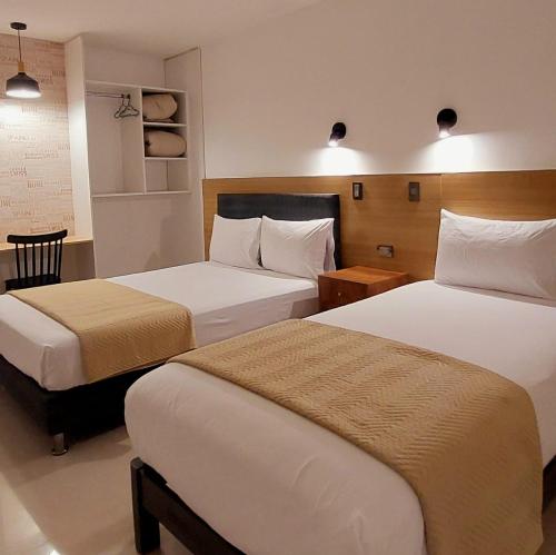 a hotel room with two beds in a room at Mandala Lux Hotel in Pisco