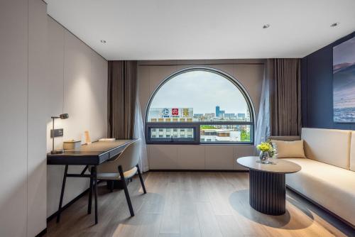 a hotel room with a bed and a desk and a window at Atour Hotel Canton Tower Pearl River Binjiang Road East Guangzhou - Free Shuttle Bus Service Between Fair And Hotel During The Canton Fair in Guangzhou