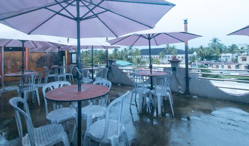 a group of tables and chairs with umbrellas at RedDoorz at Minas Place 1 Tacloban in Tacloban