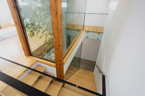 a glass staircase in a house with a window at Luxury Avenue Retreat-Sleeps 8, Fireplace, Central, Garage, 4 bedroom, 2 bathroom, BBQ in Ocean Grove