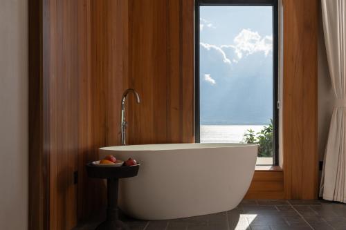 a bath tub in a bathroom with a window at Erhai Seaview Garden Villa &Dali Airport in Dali