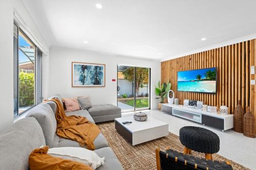 una sala de estar con un sofá y una mesa en The Bayhaven- Pet friendly Villa, en Nelson Bay