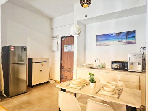 a kitchen with a table and a stainless steel refrigerator at Grand Horizon Imperium Residence Kuantan Studio City view in Kuantan