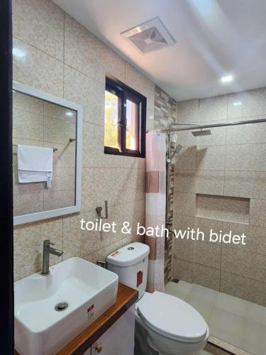 a bathroom with a toilet and a sink and a shower at Summerville Hotel and Resort in Palayan City