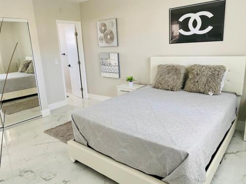 a bedroom with a large bed and a mirror at CHIC 1BR 2BA CONDO 1 Block to Aventura Mall in Aventura