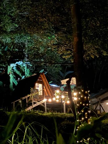 a cabin in the woods at night with lights at Glamping la cabaña in La Ermita