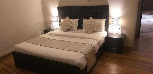 a bedroom with a large bed with white sheets and pillows at Pearl suites at Omaxe entrenity in Vrindāvan