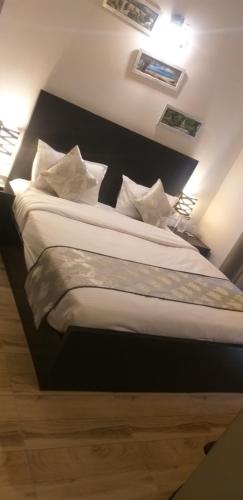 a bedroom with a large bed with white sheets and pillows at Pearl suites at Omaxe entrenity in Vrindāvan
