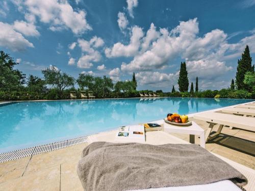 a large swimming pool with a bed and a bowl of fruit at Agriturismo Tenuta Quarrata Santo Pietro Belvedere in Ripoli