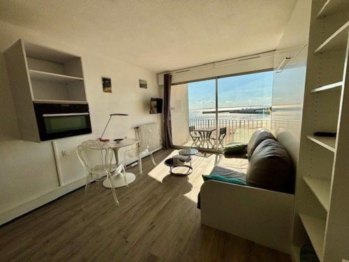 un salon avec un canapé et une grande fenêtre dans l'établissement Quiberon - Studio 27m² - Vue mer - 2 pers - Animaux admis - Parking - FR-1-478-310, à Quiberon