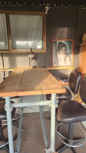 a wooden table with chairs in a room at Beachfront Sunset Bach in Piha