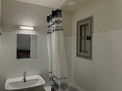 une salle de bain avec un lavabo et un rideau de douche dans l'établissement Appartement climatisé 4 pers avec parking aux Saintes-Maries-de-la-Mer - FR-1-475-216, à Saintes-Maries-de-la-Mer