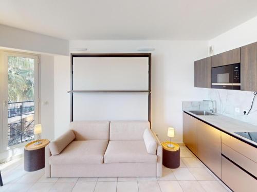 un salon avec un canapé et une cuisine dans l'établissement Studio rénové avec balcon et garage en plein cœur de Menton - FR-1-196-375, à Menton