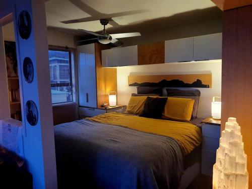 a bedroom with a bed with two lights on at Beachfront Sunset Bach in Piha