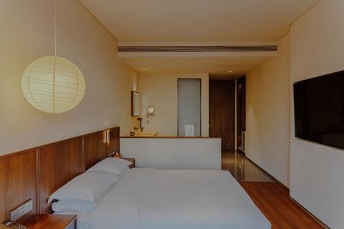a bedroom with a white bed and a flat screen tv at Reconstruction of ChaoDongli Cultural Hotel - Beijing Wangfujing Branch in Beijing