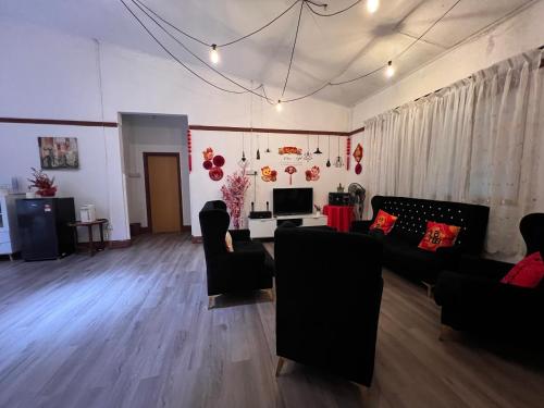 a living room with black couches and a table at Mountain View Guesthouse Cameron Highlands in Tanah Rata