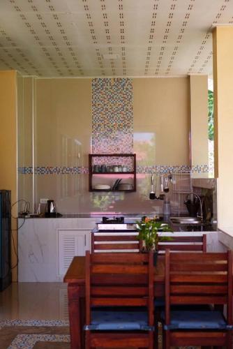 a kitchen with a table and chairs and a counter at Baan Ob-oun Homestay in Ban Khlong Chi Lat
