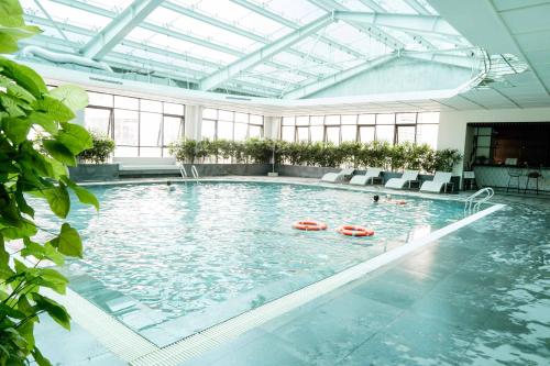 a large swimming pool with people in the water at Hotel Soleil Ha Long, Trademark Collection by Wyndham in Ha Long
