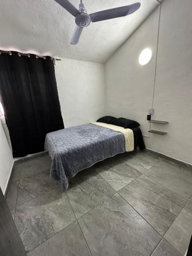 a bedroom with a bed with a ceiling fan at departamento familiar centrico cerca de playa y plazas comerciales con wifi 200 in Puerto Vallarta