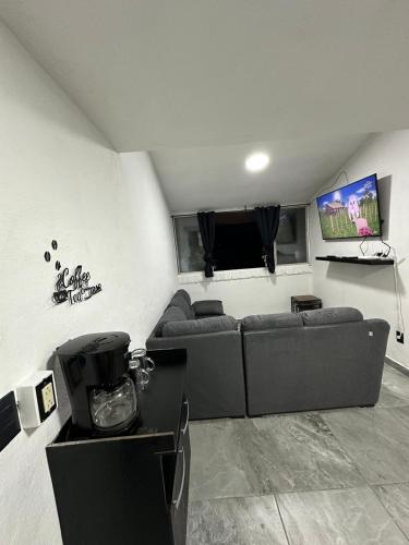 a living room with a couch and a tv at departamento familiar centrico cerca de playa y plazas comerciales con wifi 200 in Puerto Vallarta