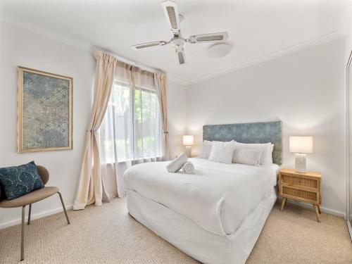 Un dormitorio blanco con una cama grande y una ventana. en Moo's Hoose, en Margaret River Town