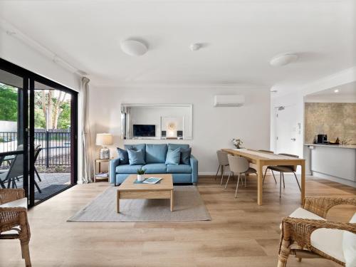 a living room with a blue couch and a table at Moo's Hoose in Margaret River Town