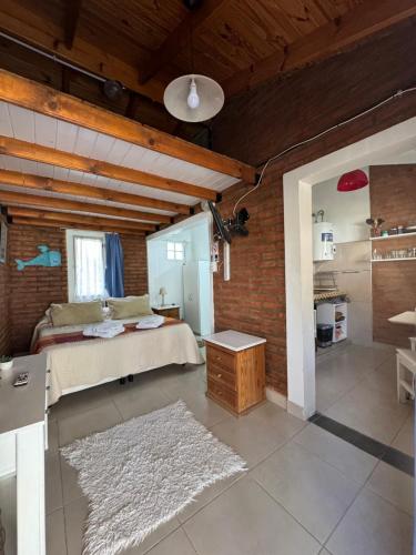 a bedroom with a bed and a brick wall at El marinero puerto pirámides in Puerto Pirámides