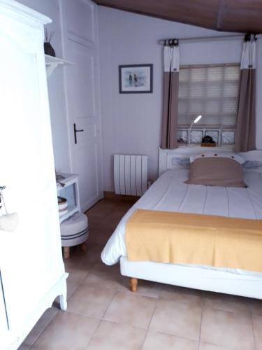 une chambre avec un grand lit dans une pièce dans l'établissement Les volets bleus, à Saint-Gilles-Croix-de-Vie