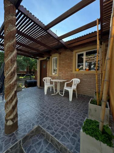 a patio with a wooden pergola and a table and chairs at El marinero puerto pirámides in Puerto Pirámides