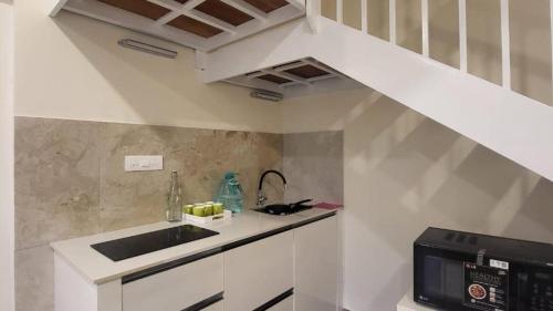 a kitchen with a sink and a microwave at Mountain Serenity Meppadi, Wayanad in Kalpetta