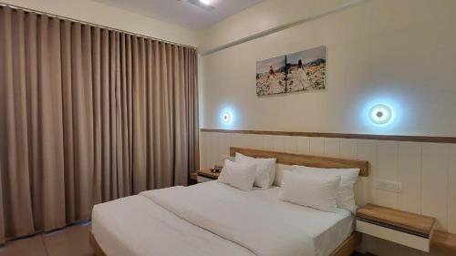 a bedroom with a large white bed and a window at Mountain Serenity Meppadi, Wayanad in Kalpetta