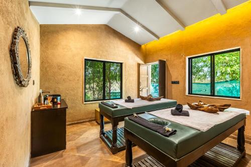 a room with two beds and a mirror at Sterling Orient Woods Pench in Silāri