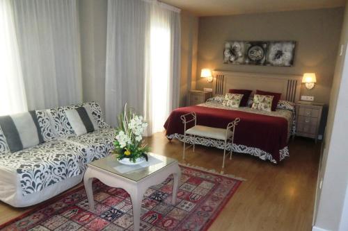 a living room with a bed and a couch at Hotel Vila Mar in Cambrils