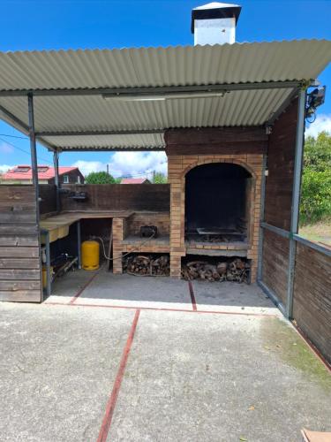 an open garage with a building with a fireplace at Gites le Matarum dortoir 3 petits lits in Cilaos