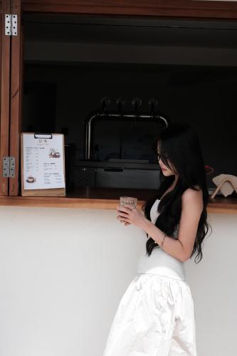 a woman is leaning against a counter holding a drink at Erhai Seaview Garden Villa &Dali Airport in Dali