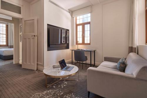 a living room with a couch and a table at The Inchcolm by Ode Hotels in Brisbane
