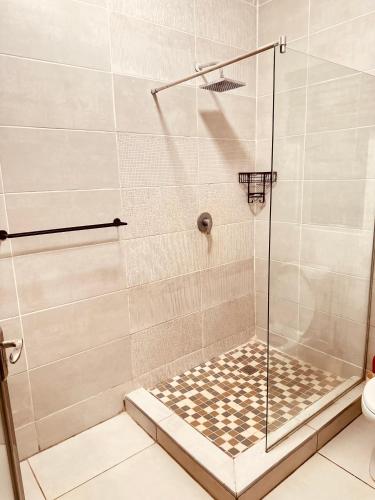 a shower with a glass door in a bathroom at LIVE-INN LUXURY SUITES in Mahalapye