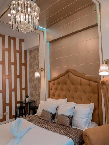 Un dormitorio con una cama grande y una lámpara de araña. en Toffee Staycation, en Tagaytay