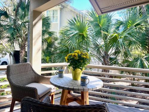 a table and chairs on a porch with a vase of flowers at 2975 Deer Point Dr in Johns Island