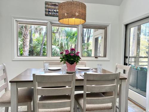 a dining room with a table and chairs and windows at 2975 Deer Point Dr in Johns Island