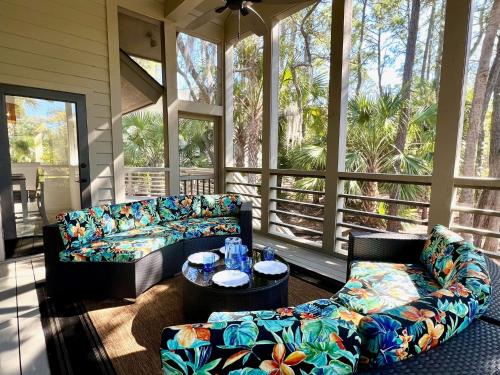 a screened in porch with a couch and a table at 2975 Deer Point Dr in Johns Island