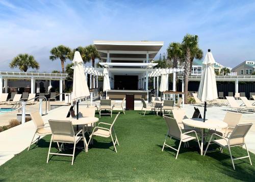 a group of tables and chairs with white umbrellas at 2975 Deer Point Dr in Johns Island