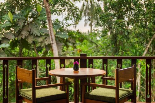a small table and two chairs on a balcony at Beehouse Dijiwa Ubud in Ubud