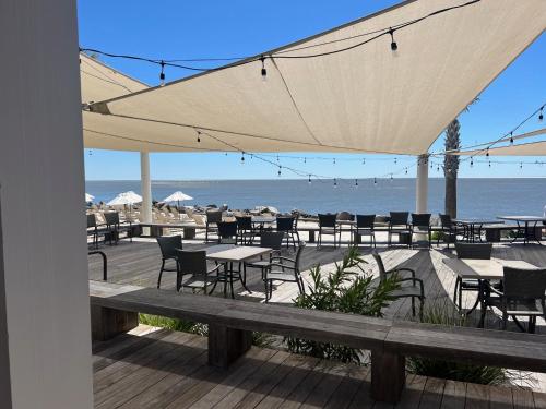 a deck with tables and chairs on the beach at 2975 Deer Point Dr in Johns Island